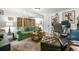 Comfortable living area features a green couch, leather ottoman, and an eclectic assortment of art at 2131 Eliot St, Denver, CO 80211