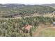 Aerial shot of the property, surrounded by forest and mountains at 8851 Blue Creek Rd, Evergreen, CO 80439