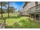 View of the backyard featuring a spacious lawn and a wooden deck with stairs at 8851 Blue Creek Rd, Evergreen, CO 80439