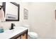 A bathroom with a dark framed mirror, vanity and white toilet at 8851 Blue Creek Rd, Evergreen, CO 80439