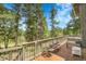 Spacious wooden deck overlooking a serene forest backdrop and sunny sky at 8851 Blue Creek Rd, Evergreen, CO 80439