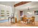 Bright dining area featuring wood floors, wood beams, a modern chandelier, and scenic views from the window at 8851 Blue Creek Rd, Evergreen, CO 80439