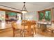 Inviting dining room featuring hardwood floors, a wooden table with chairs, and open access to a living space at 8851 Blue Creek Rd, Evergreen, CO 80439