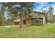 Charming gray home with a lawn surrounded by evergreen trees, boasting a beautiful and welcoming entrance with a two-car garage at 8851 Blue Creek Rd, Evergreen, CO 80439