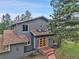 View of the house exterior, showcasing unique architecture, wood siding, and brick steps at 8851 Blue Creek Rd, Evergreen, CO 80439