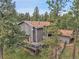 Aerial view of a house showcasing the roof, deck, and surrounding forest at 8851 Blue Creek Rd, Evergreen, CO 80439