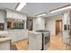 Modern kitchen with white cabinets, granite countertops, stainless steel appliances, wood floors, and bright lighting at 8851 Blue Creek Rd, Evergreen, CO 80439