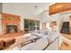 Bright living room with a fireplace, hardwood floors, lots of natural light, and access to an outdoor balcony at 8851 Blue Creek Rd, Evergreen, CO 80439