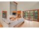 Bright living room features a cozy fireplace, wood floors, and sliding glass doors to a deck at 8851 Blue Creek Rd, Evergreen, CO 80439