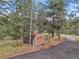 Exterior view of a storage shed on the property, nestled amongst pine trees at 8851 Blue Creek Rd, Evergreen, CO 80439