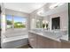 Bright bathroom featuring a soaking tub, double vanity with modern sinks, and a large window at 3885 Vrain St, Denver, CO 80212