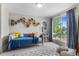 Cozy bedroom featuring a plush rug, a comfortable daybed, and a large window for natural light at 3885 Vrain St, Denver, CO 80212