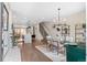 Open dining area with contemporary chandelier, glass table, and stylish decor leading to the kitchen at 3885 Vrain St, Denver, CO 80212