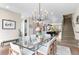 Elegant dining area with glass table, modern chandelier, flowing seamlessly into the open-concept kitchen and staircase at 3885 Vrain St, Denver, CO 80212