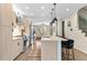 Modern kitchen with stainless steel appliances, center island with seating, and open layout to living area at 3885 Vrain St, Denver, CO 80212