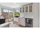 Stylish wet bar with glass cabinets, a wine fridge, and access to an outdoor deck at 3885 Vrain St, Denver, CO 80212
