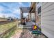 Back deck with pergola, stone accents on the home, and view of the neighborhood with fenced yard at 7265 S Millbrook Ct, Aurora, CO 80016