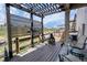 Relaxing back deck under a pergola, featuring comfortable seating and a view of the surrounding landscape at 7265 S Millbrook Ct, Aurora, CO 80016