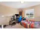 A bedroom with a large window for natural light, a desk with computer setup, and comfortable carpet at 7265 S Millbrook Ct, Aurora, CO 80016