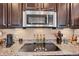 Modern kitchen with granite countertops, stainless steel appliances, and cooktop at 7265 S Millbrook Ct, Aurora, CO 80016