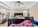 Spacious main bedroom with a black tufted headboard, complemented by natural lighting and a ceiling fan at 7265 S Millbrook Ct, Aurora, CO 80016