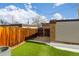 Fenced backyard featuring an artificial lawn, access gate, and low-maintenance landscaping at 12893 W Alameda Dr, Lakewood, CO 80228