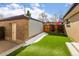 Fenced backyard featuring an artificial lawn, gate, exterior storage, and backyard access at 12893 W Alameda Dr, Lakewood, CO 80228