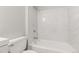 Bright bathroom with white marble-style tile surround at 12893 W Alameda Dr, Lakewood, CO 80228