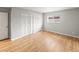 Bright bedroom features light hardwood floors, grey walls, closet, and a window at 12893 W Alameda Dr, Lakewood, CO 80228