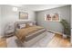 Staged bedroom with plush bed, stylish rug, and plenty of natural light streaming through the window at 12893 W Alameda Dr, Lakewood, CO 80228