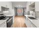 Well-lit kitchen with white cabinets, stainless appliances, and hardwood floors throughout at 12893 W Alameda Dr, Lakewood, CO 80228