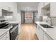 Modern kitchen featuring new stainless steel appliances, sleek white cabinets, and hardwood floors at 12893 W Alameda Dr, Lakewood, CO 80228