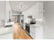 Bright kitchen with stainless steel appliances, white cabinets, subway tile backsplash, and hardwood floors at 12893 W Alameda Dr, Lakewood, CO 80228