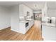 Bright eat-in kitchen with stainless steel appliances, white cabinets, subway tile backsplash, and hardwood floors at 12893 W Alameda Dr, Lakewood, CO 80228