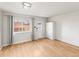 Open living area featuring a large window, closet, white walls and door, and hardwood floors at 12893 W Alameda Dr, Lakewood, CO 80228