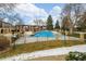 Inviting fenced community pool filled with water and surrounded by trees and nearby residential buildings at 12893 W Alameda Dr, Lakewood, CO 80228