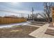 Large backyard with new fence, patio, and landscape area with snow on the ground on a sunny day at 1330 E 90Th Ave, Thornton, CO 80229