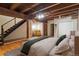 Bedroom featuring wood beams, hardwood floors, and modern staircase at 2960 Inca St # 116, Denver, CO 80202