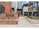 Watertower Lofts entrance with brick facade, flower bed, and walkway leading to the front doors at 2960 Inca St # 116, Denver, CO 80202