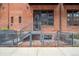 Brick townhouse featuring a fenced-in patio and stair access to the unit's entrance at 2960 Inca St # 116, Denver, CO 80202