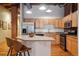 Stylish kitchen featuring stainless steel appliances, wooden cabinetry, and a granite countertop island at 2960 Inca St # 116, Denver, CO 80202
