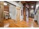 Spacious living area with exposed brick and beams, sliding barn door, and hardwood floors at 2960 Inca St # 116, Denver, CO 80202