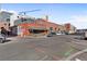 Street view featuring a corner building with an outdoor seating area, with cars parked along the street at 2960 Inca St # 116, Denver, CO 80202