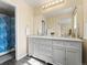 Bathroom with double sinks, a large mirror, a shower and updated vanity at 18554 E Vassar Dr, Aurora, CO 80013