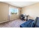 Bedroom with large window, neutral walls, and a cozy sitting area with comfortable futon at 18554 E Vassar Dr, Aurora, CO 80013