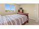 Bedroom featuring a comfortable bed, dresser, and large window at 18554 E Vassar Dr, Aurora, CO 80013
