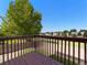 Backyard view from deck with wood railing, overlooking lush green space and neighborhood at 18554 E Vassar Dr, Aurora, CO 80013