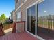Deck with sliding door leading inside, overlooking green landscape at 18554 E Vassar Dr, Aurora, CO 80013