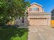 Charming two-story home featuring brick accents, red shutters, and a well-maintained lawn at 18554 E Vassar Dr, Aurora, CO 80013