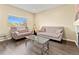 Cozy living room featuring neutral-toned sofas, a glass coffee table, and a large window with natural light at 18554 E Vassar Dr, Aurora, CO 80013